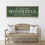 a wooden bench sitting in front of a white wall