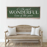 a wooden bench sitting in front of a white wall