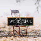 a wooden rocking chair with a sign that says it's the most wonderful time