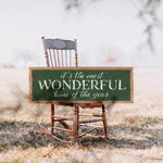 a wooden rocking chair with a sign that says it's the most wonderful time