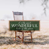 a wooden rocking chair with a sign that says it's the most wonderful time