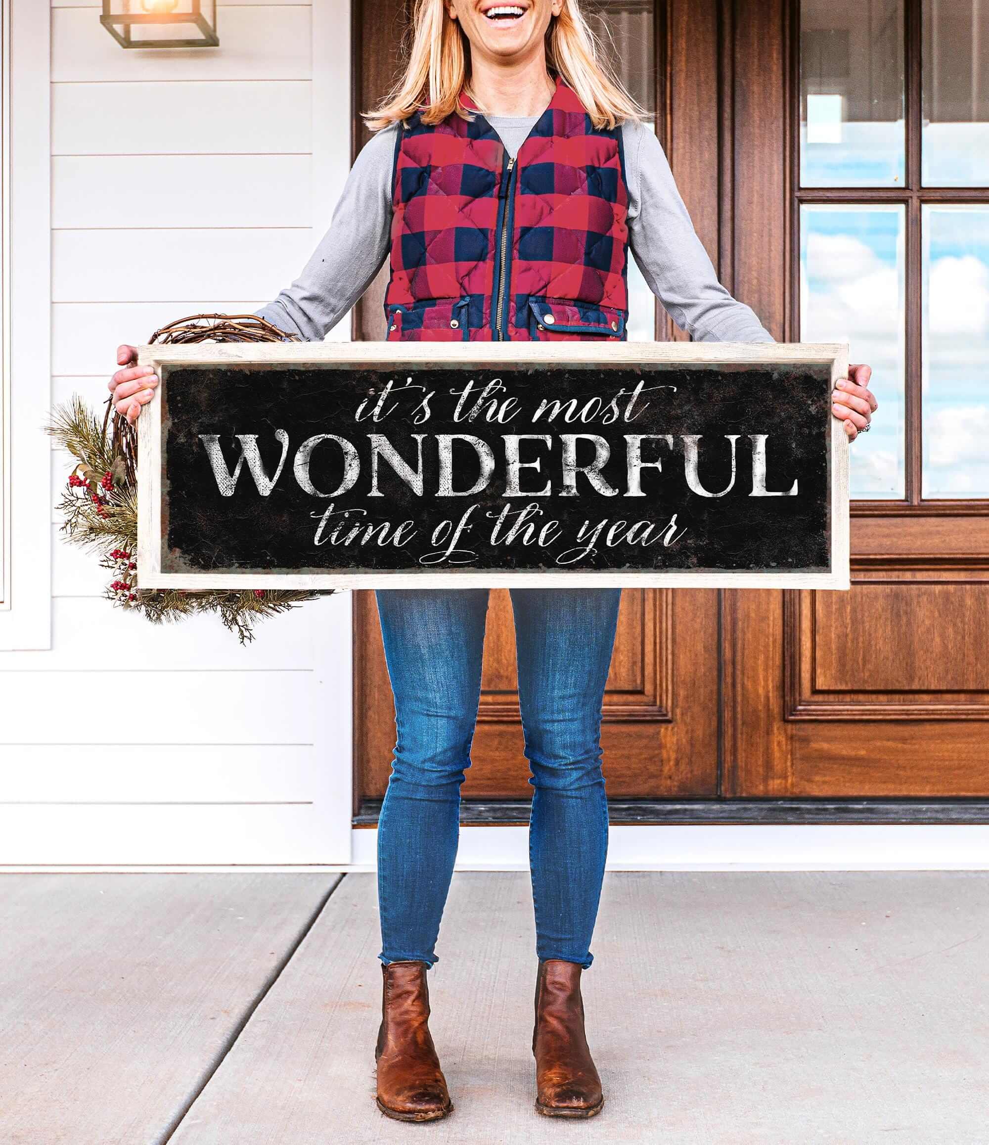 a woman holding a sign that says it's the most wonderful time of the