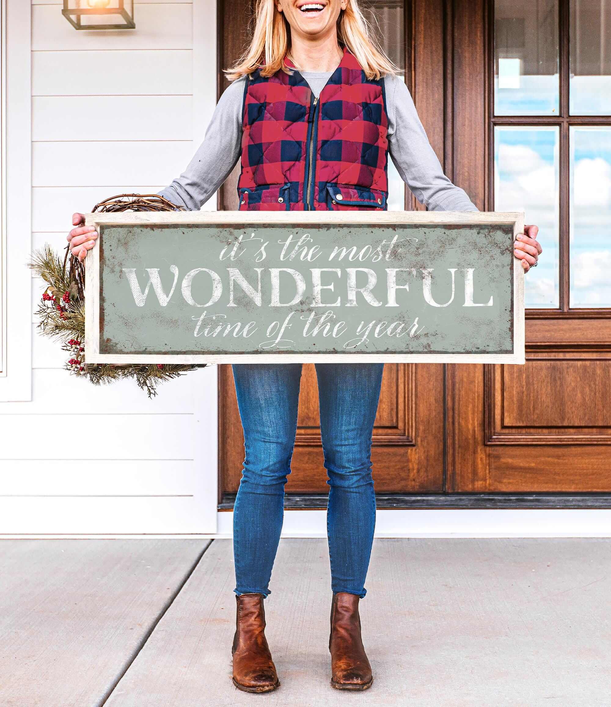a woman holding a sign that says it's the most wonderful time of the