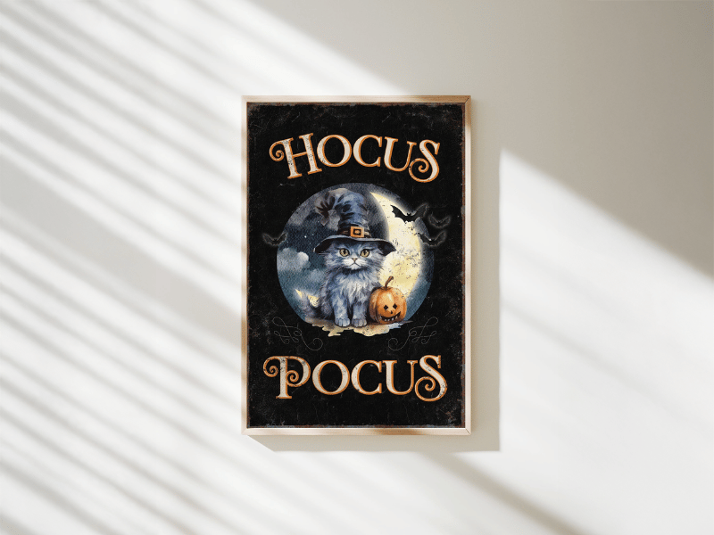 Framed "Hocus Pocus" poster with a cat in a witch hat, a pumpkin, and bats under a full moon.