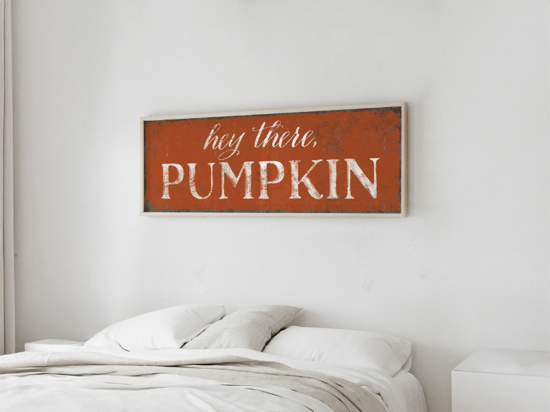 A sign above a bed reads "hey there, PUMPKIN" in white letters on an orange background.