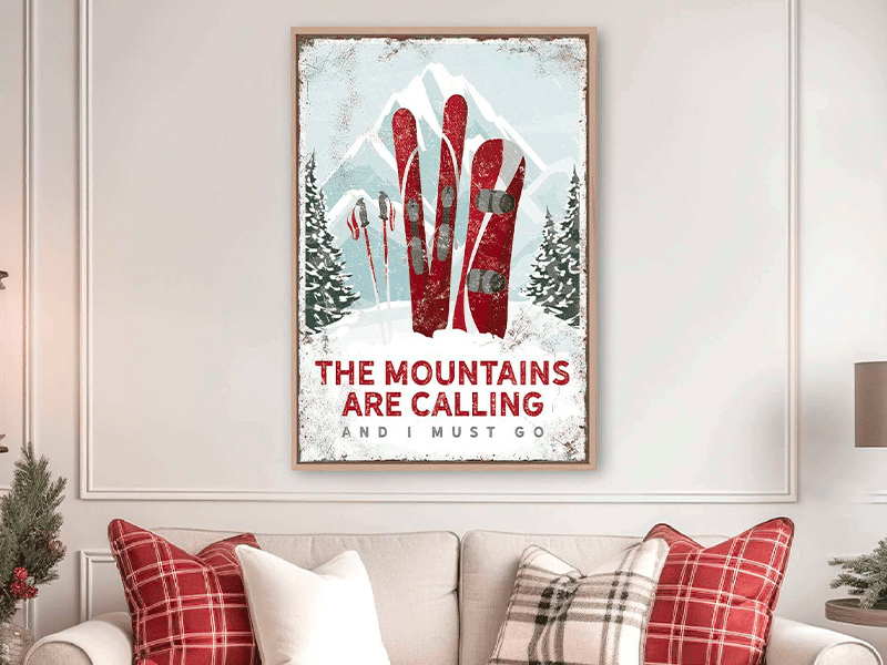 Framed mountain art print with skis, reading "The mountains are calling and I must go," on a desk.