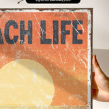 a person holding up a sign that says beach life