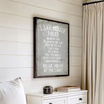a framed sign with a list of rules for a lake house, hanging on a wall next to a white dresser.
