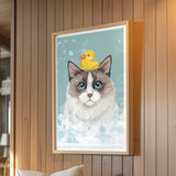 A framed illustration of a cat with a yellow rubber duck on its head, set against a blue background with white bubbles.