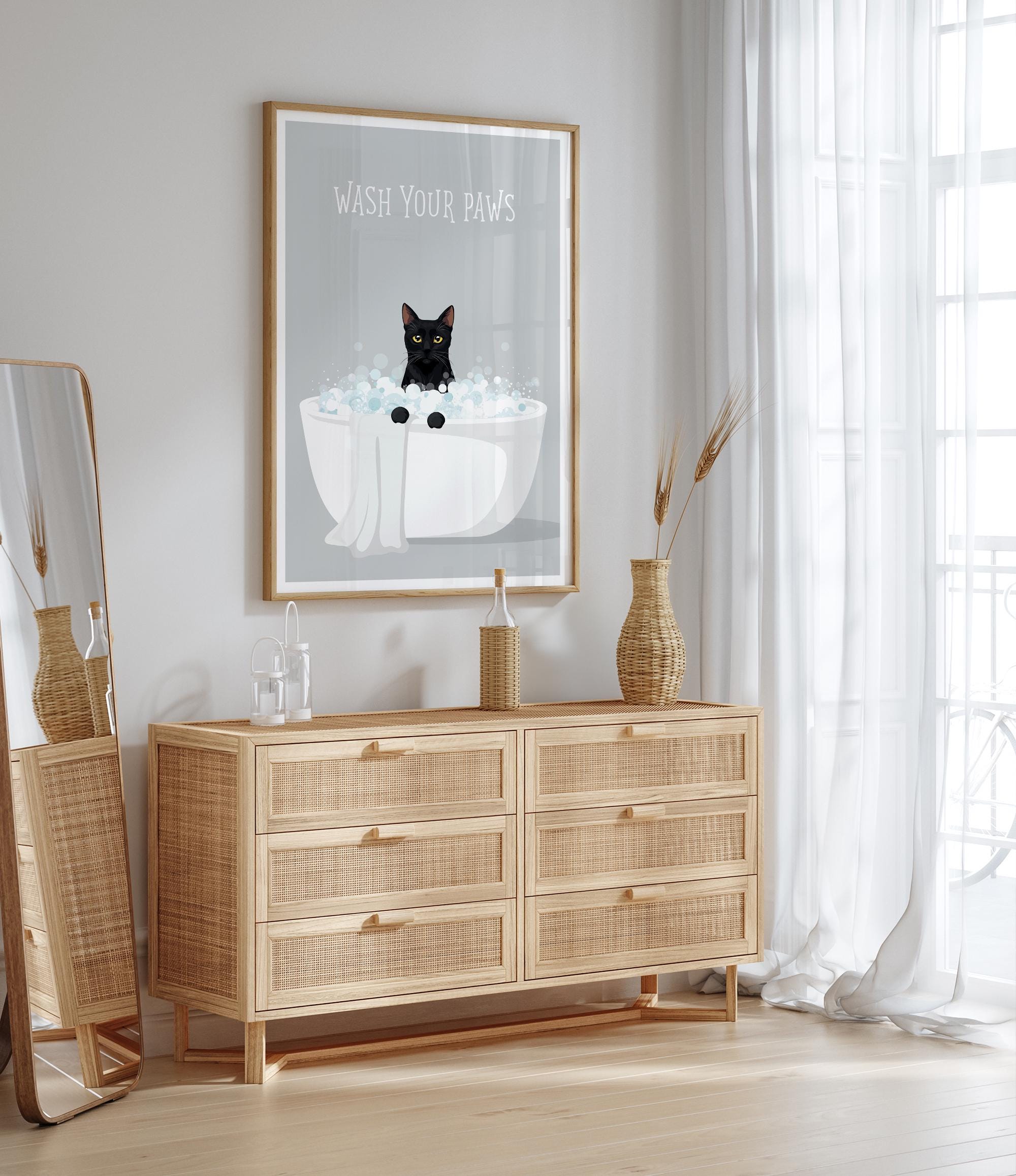a wooden dresser with a framed poster of a cat sitting in a bathtub, accompanied by the text "WASH YOUR PAWS".