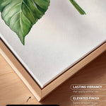 a close-up view of a canvas print with a natural frame, showcasing a detailed painting of a green leaf.