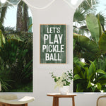 a picture of a play pickle ball sign on a wall