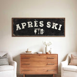 a wooden dresser with a sign above it that says "APRÈS SKI", and there are two white chairs and a vase with flowers on the dresser.