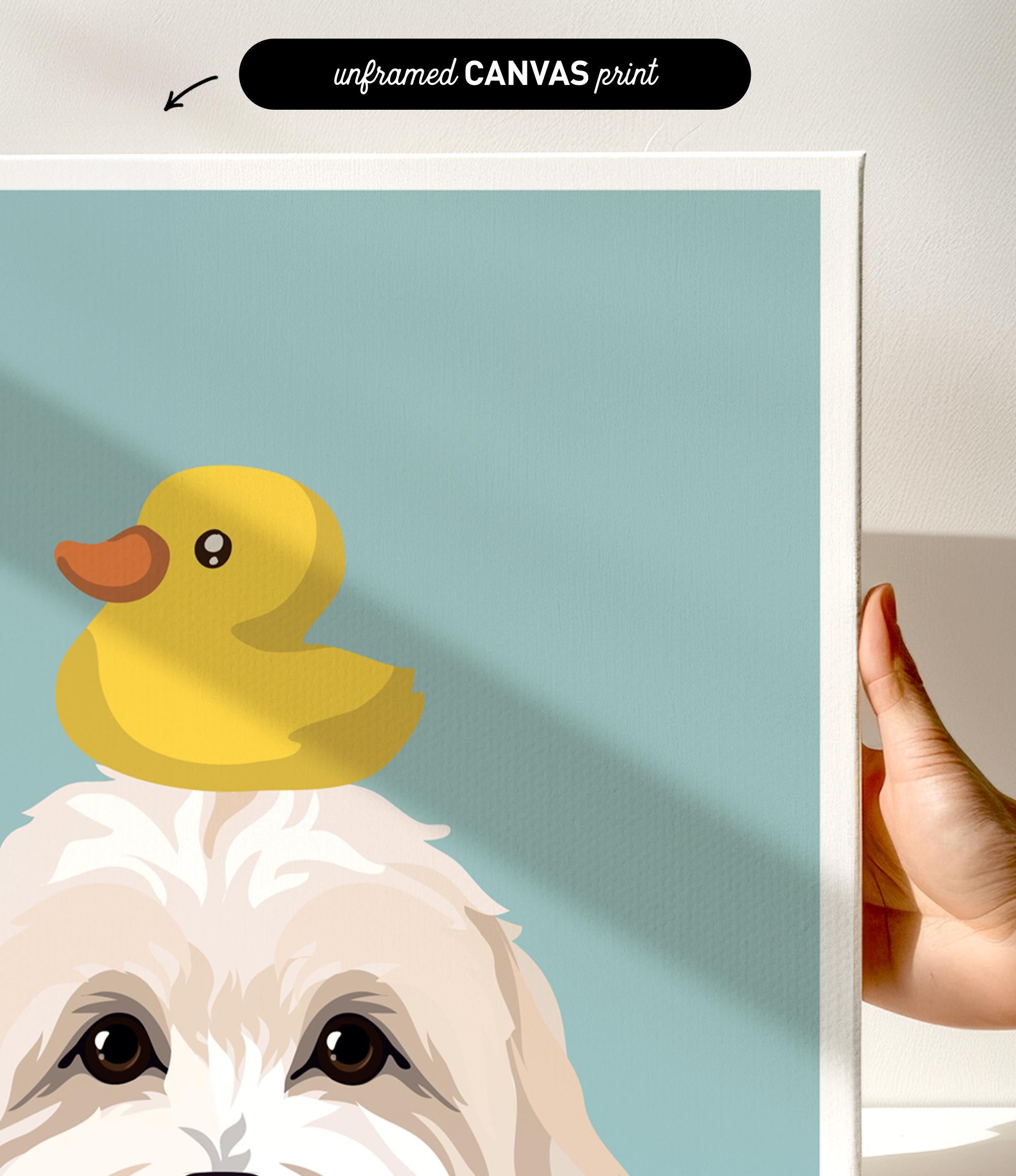 A hand is holding a framed print featuring a cartoon image of a duck sitting on a dog's head.