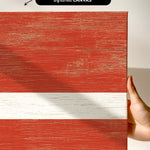 a hand holding a piece of wood with a flag painted on it