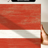 a hand holding a piece of wood with a flag painted on it