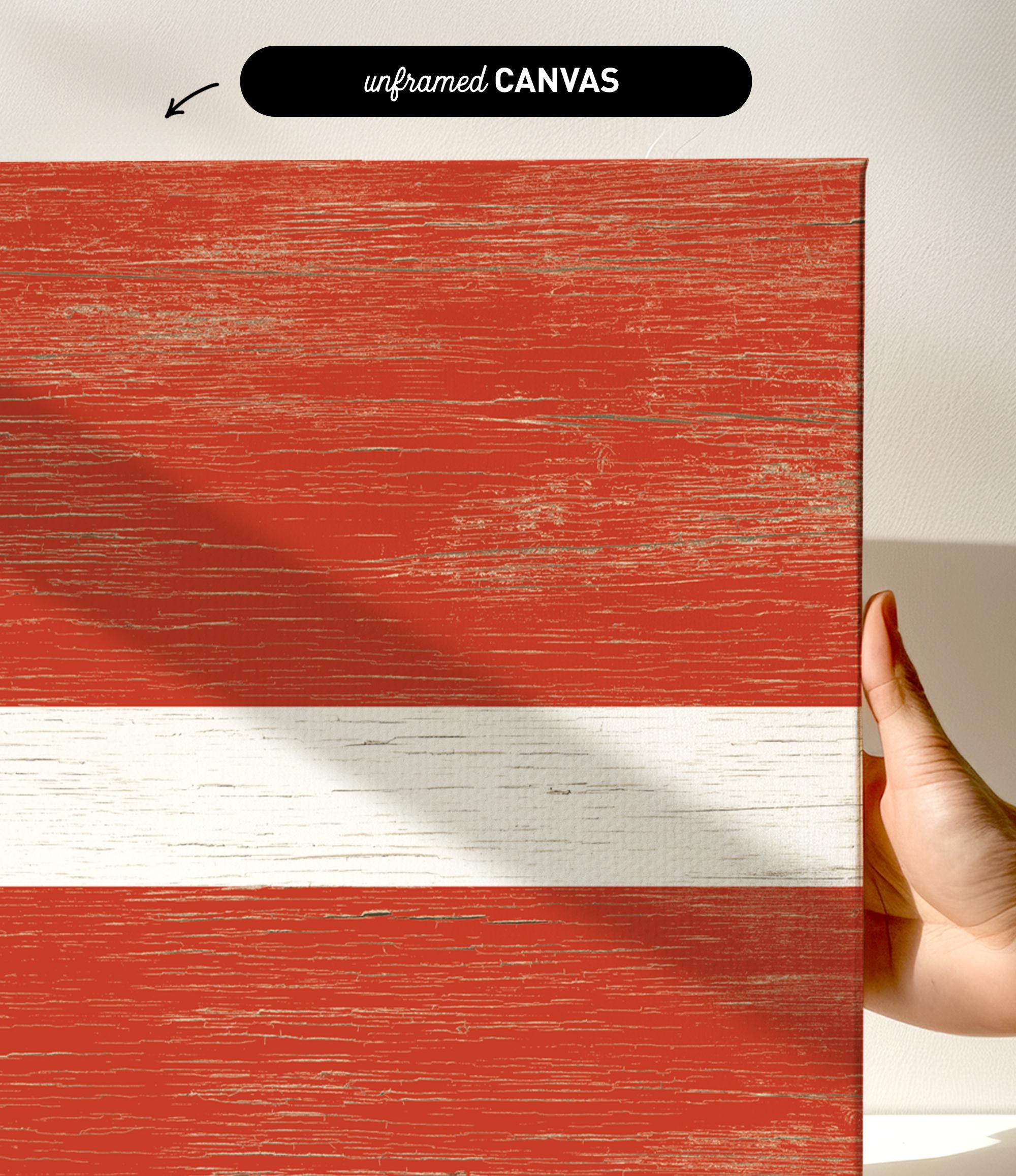 a hand holding a piece of wood with a flag painted on it