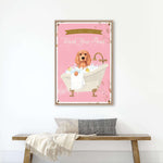 A framed poster with a dog sitting in a bathtub, surrounded by bubbles, is hanging on a white wall above a wooden bench.