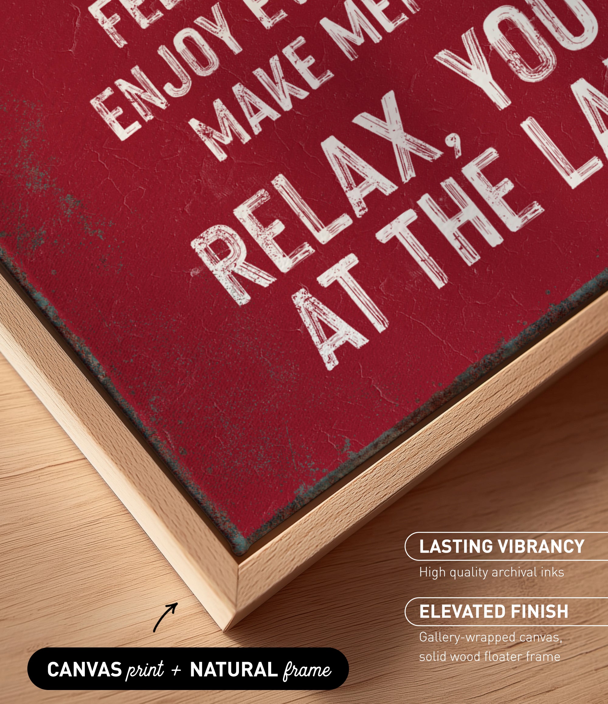 The image is a close-up of a maroon-colored canvas print with white text, placed on a wooden surface.