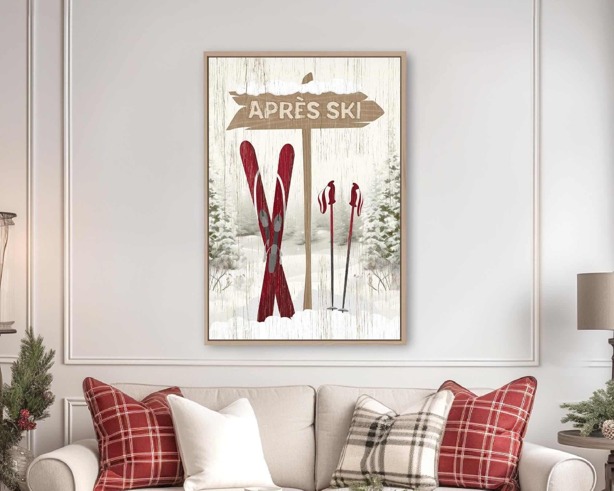 a cozy living room with a white sofa adorned with red and white plaid throw pillows. Above the sofa, there is a framed picture of a ski sign with the word "APRES" written on it. The room also includes a coffee table with a tray and a few decorative items, creating a warm and inviting atmosphere.
