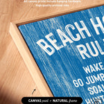 Close-up of the Beach House Rules Sign in ocean blue painted wood with white text, displayed in a natural wood frame on a wooden surface—ideal coastal wall art or beach house decor.
