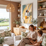A woman and a young boy are sitting together on a couch in a cozy living room, with a large window overlooking a scenic outdoor view. The room is decorated with various plants, a hanging lamp, and a framed artwork on the wall.