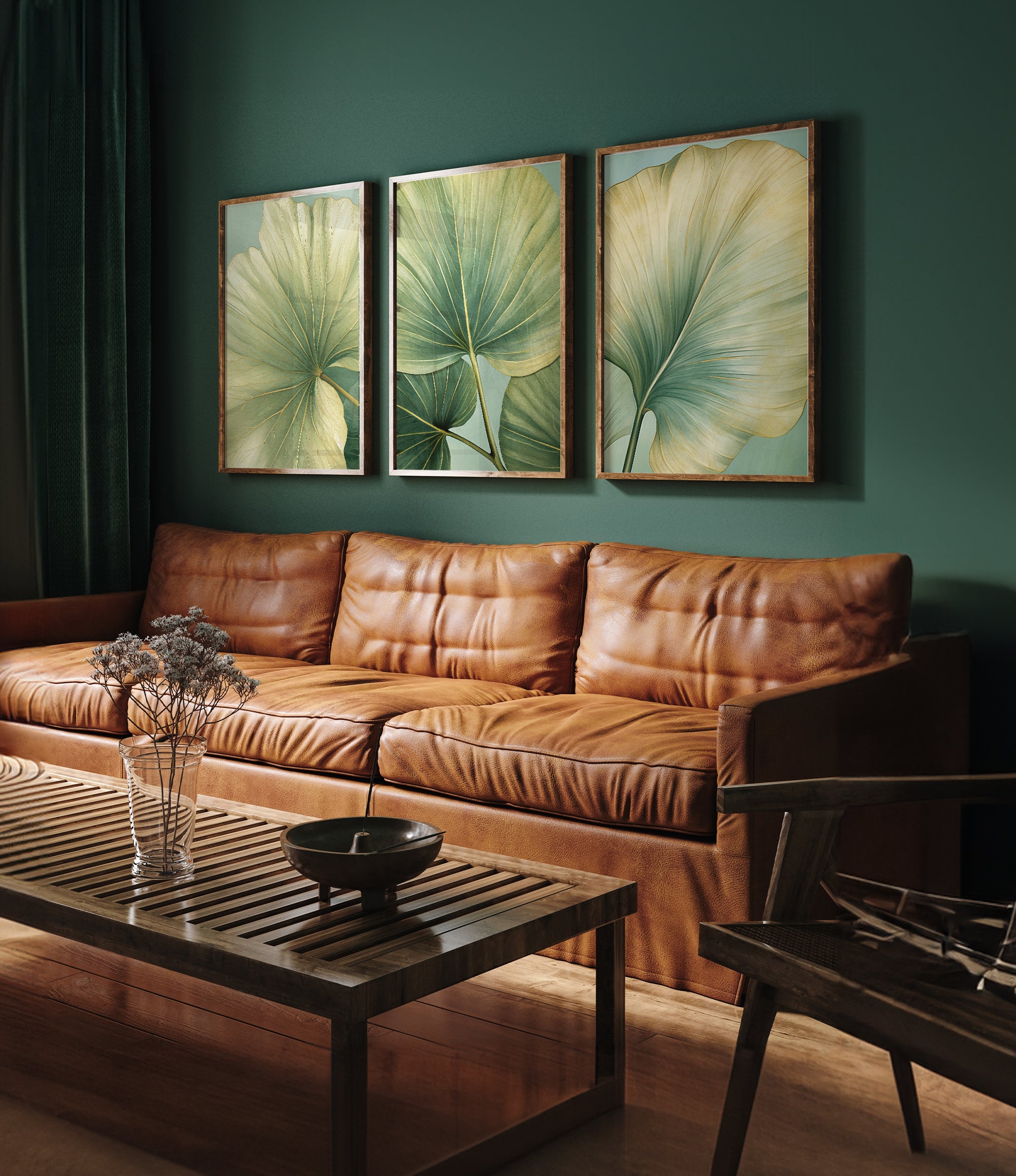 a living room with a brown leather couch, a wooden coffee table, and three framed prints of green leaves on the wall.