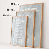 three framed beach house rules posters, each with a different size and orientation, displayed on a white wall.