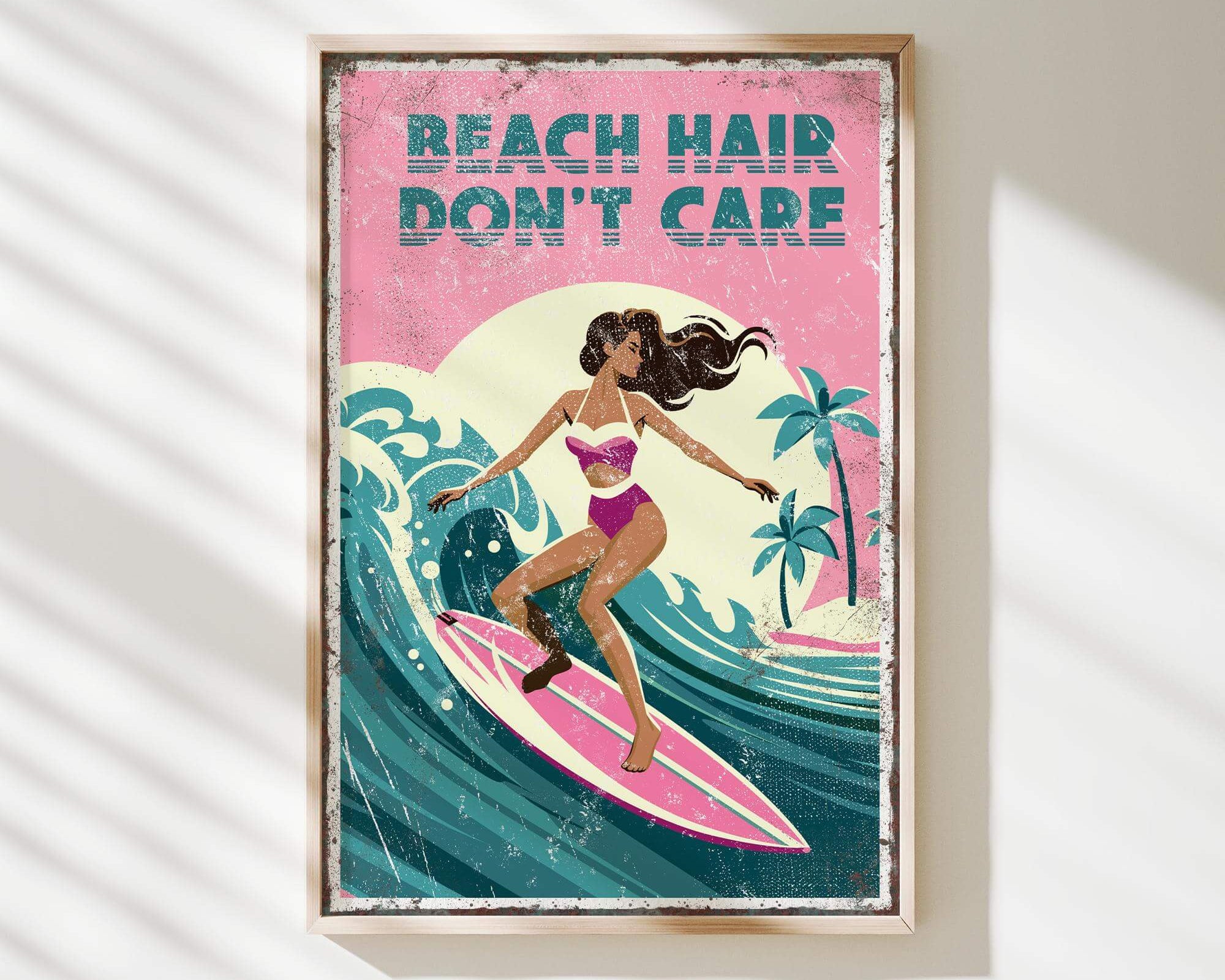 A framed poster with a woman surfing on a pink surfboard, with the text "REACH HAIR DON'T CARE" written above her.