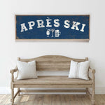 a wooden bench with two striped pillows, and above it is a framed sign with the text "APRÈS SKI" in white letters.