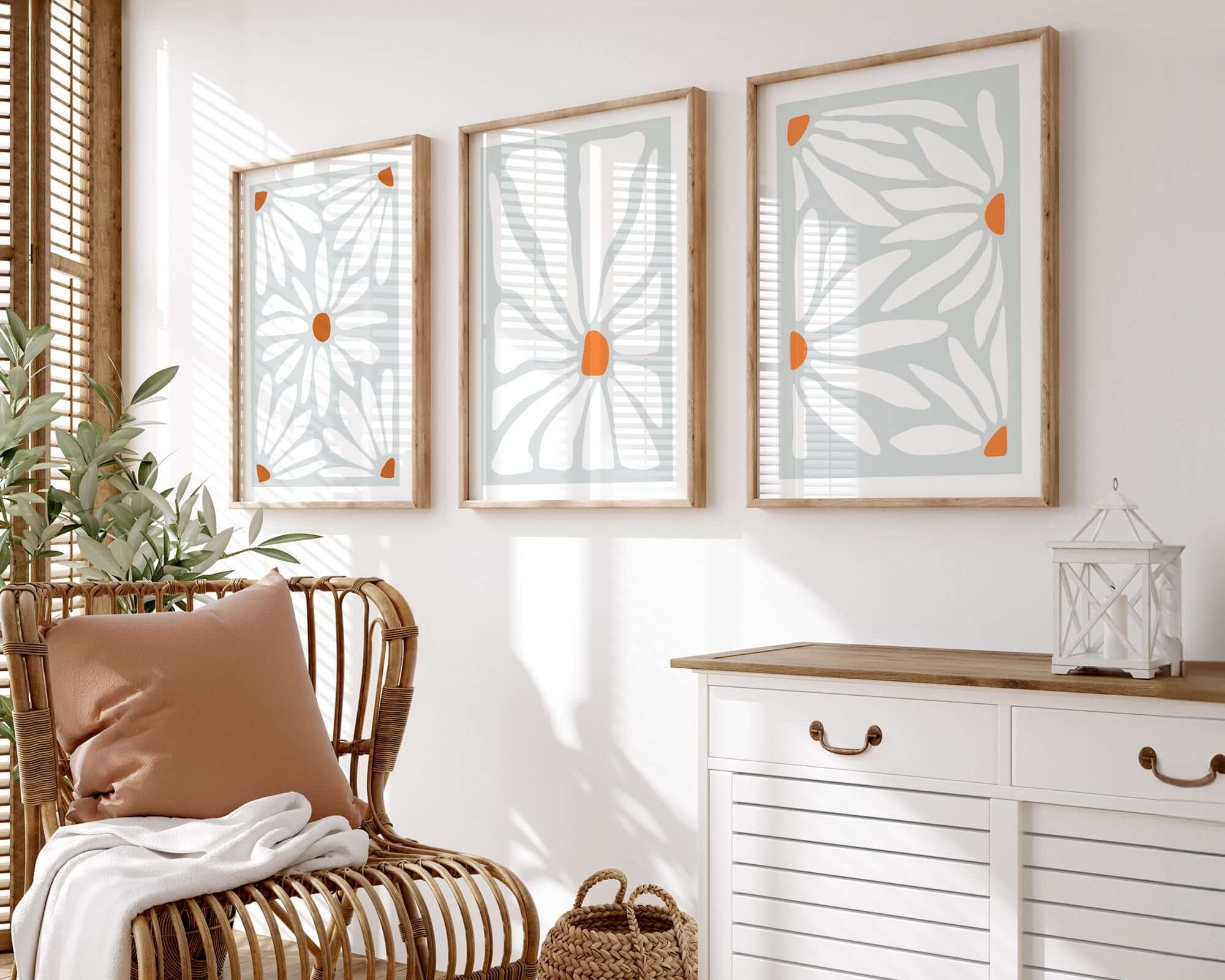Rattan chair with cushion and throw beside a white cabinet and the Flower Blocks Triptych | Set of Three Prints | 014 on a sunny wall—ideal for adding cozy charm to your home decor.