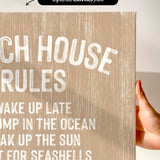 a hand holding a canvas print with the text "CHEACH HOUSE RULES" written on it.