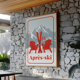 a framed poster with a mountain landscape and two red Adirondack chairs, mounted on a stone wall.