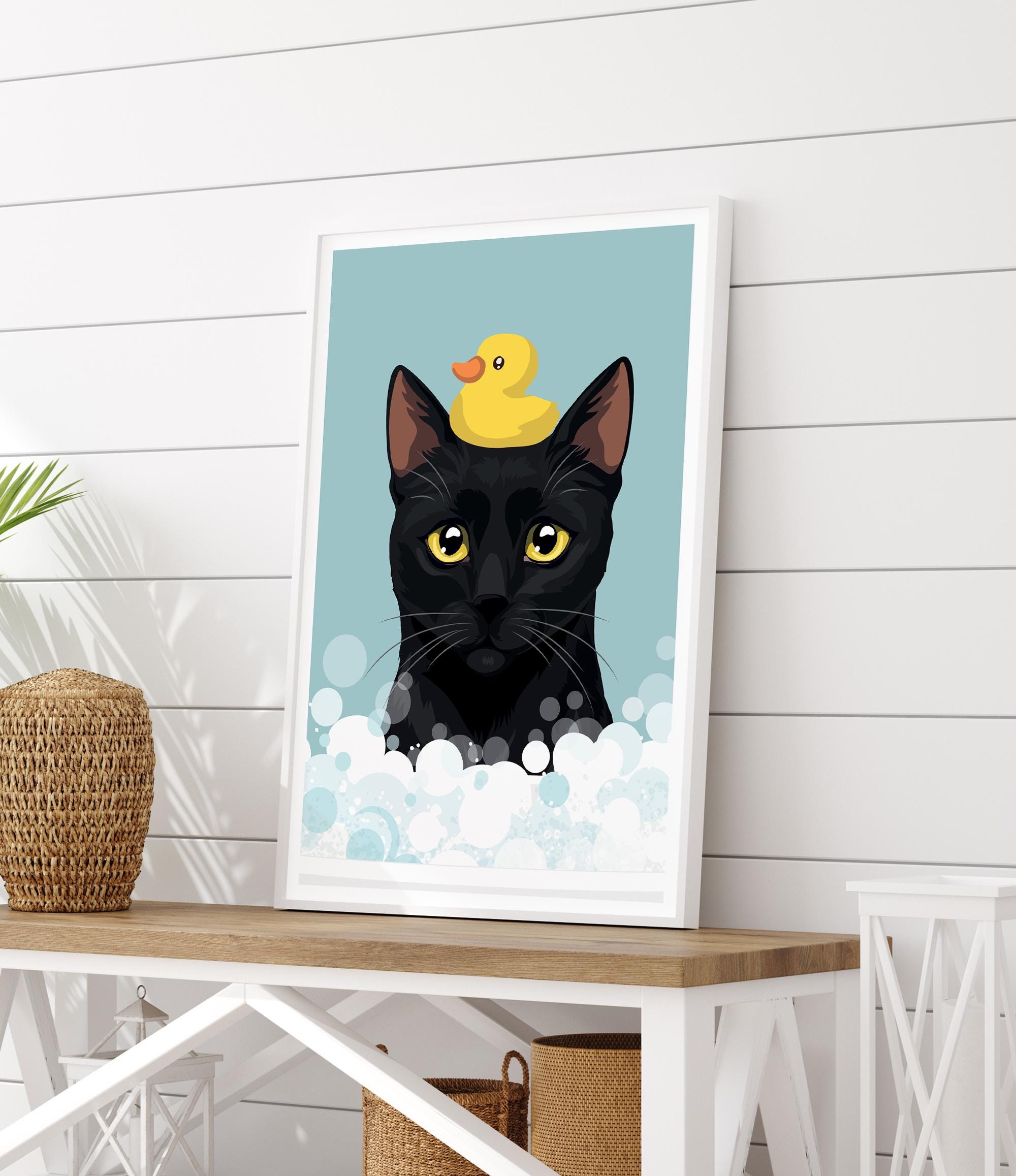 A framed illustration of a black cat with a yellow rubber duck on its head, set against a blue background with white bubbles.