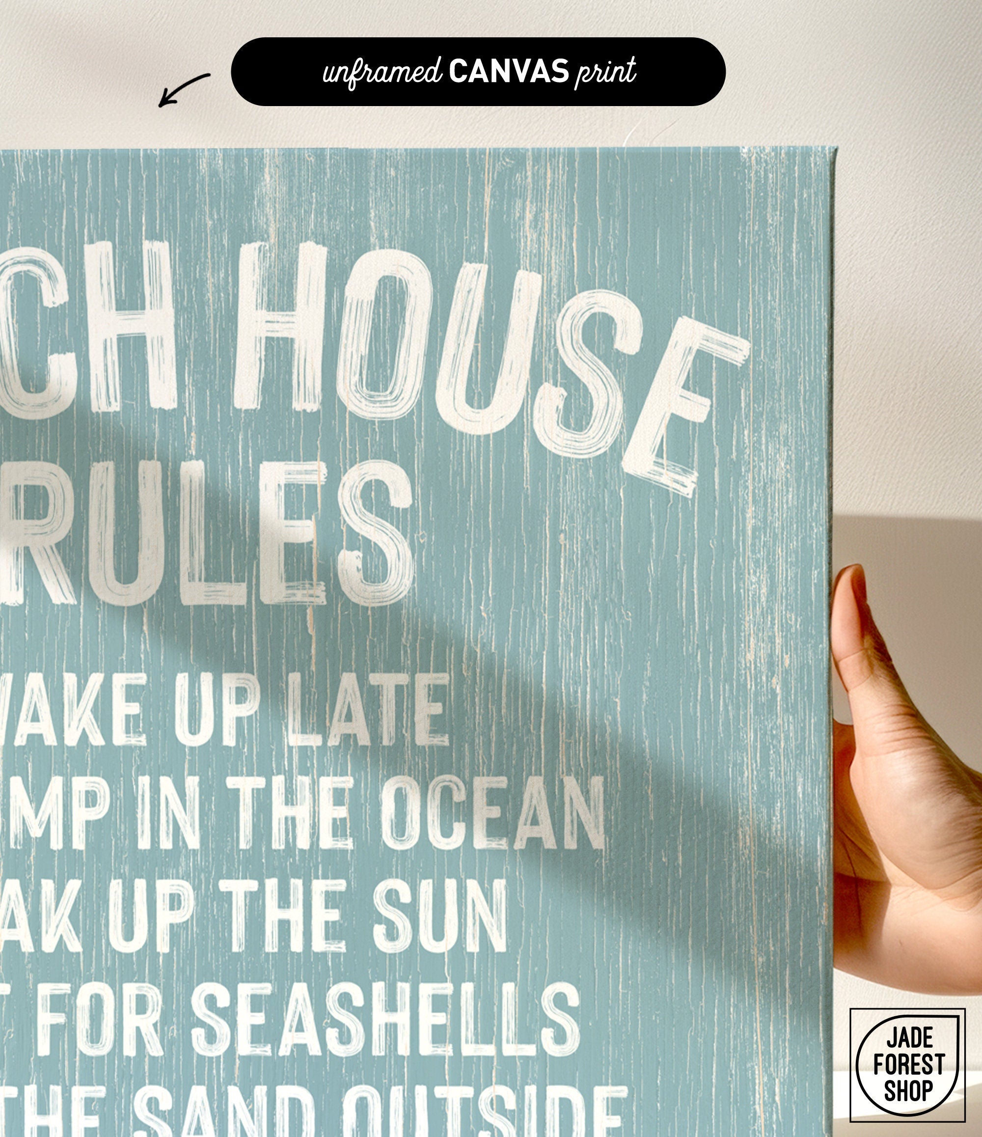 A hand holds the Beach House Rules Sign in Tide, crafted from painted wood—coastal wall art perfect for your space.