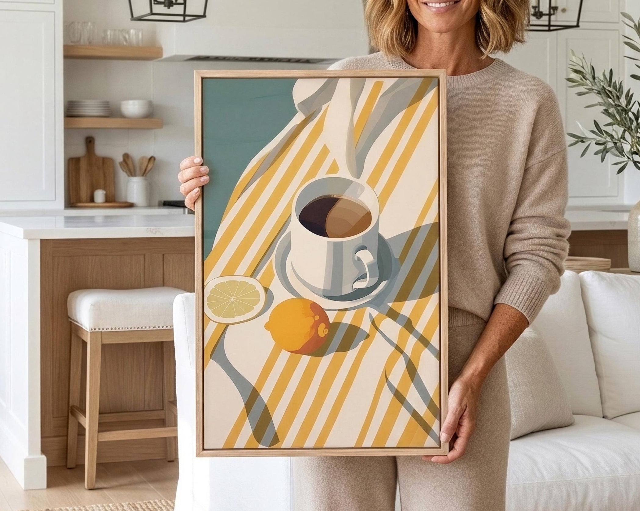 A woman is holding a framed print of a still life composition featuring a cup, lemon, and orange on a striped tablecloth.