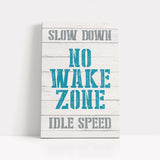 a wooden sign that says slow down no wake zone