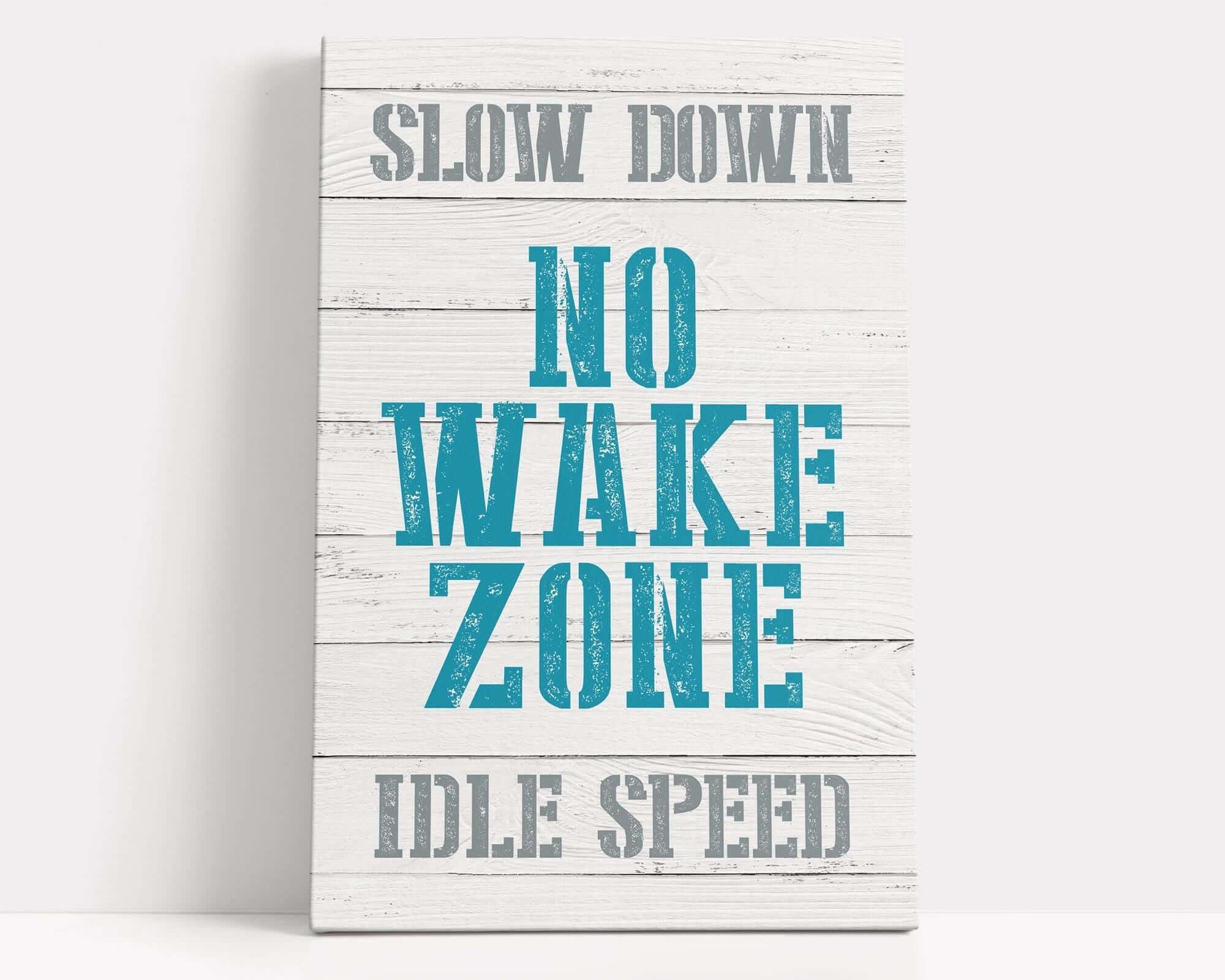 a wooden sign that says slow down no wake zone