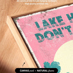 The image is a framed print with a pink background and the text "LAKES DON'T T" printed on it.