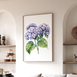 a framed painting of purple hydrangeas hanging on a wall in a living room.