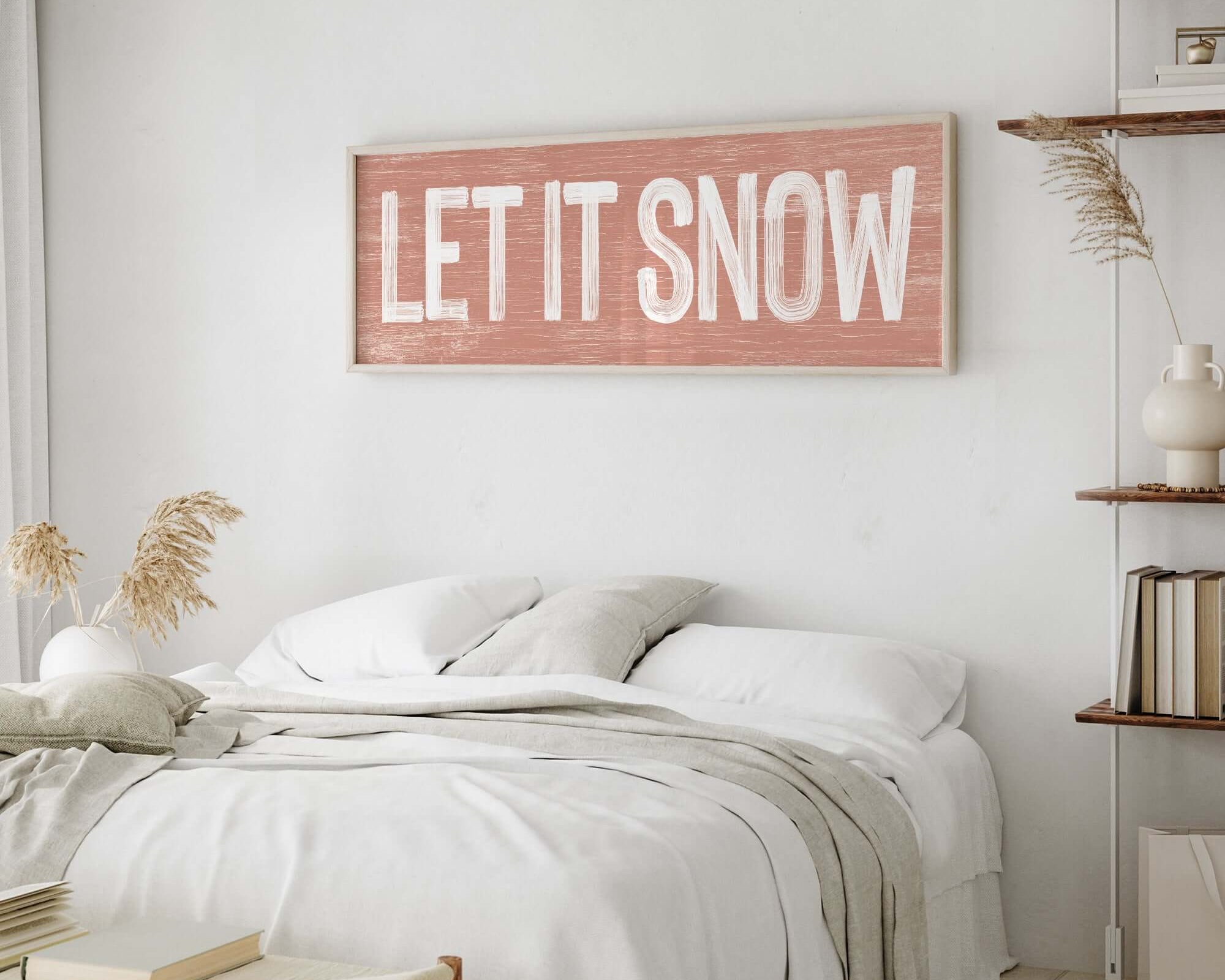a bedroom with a white bed and a wooden sign on the wall