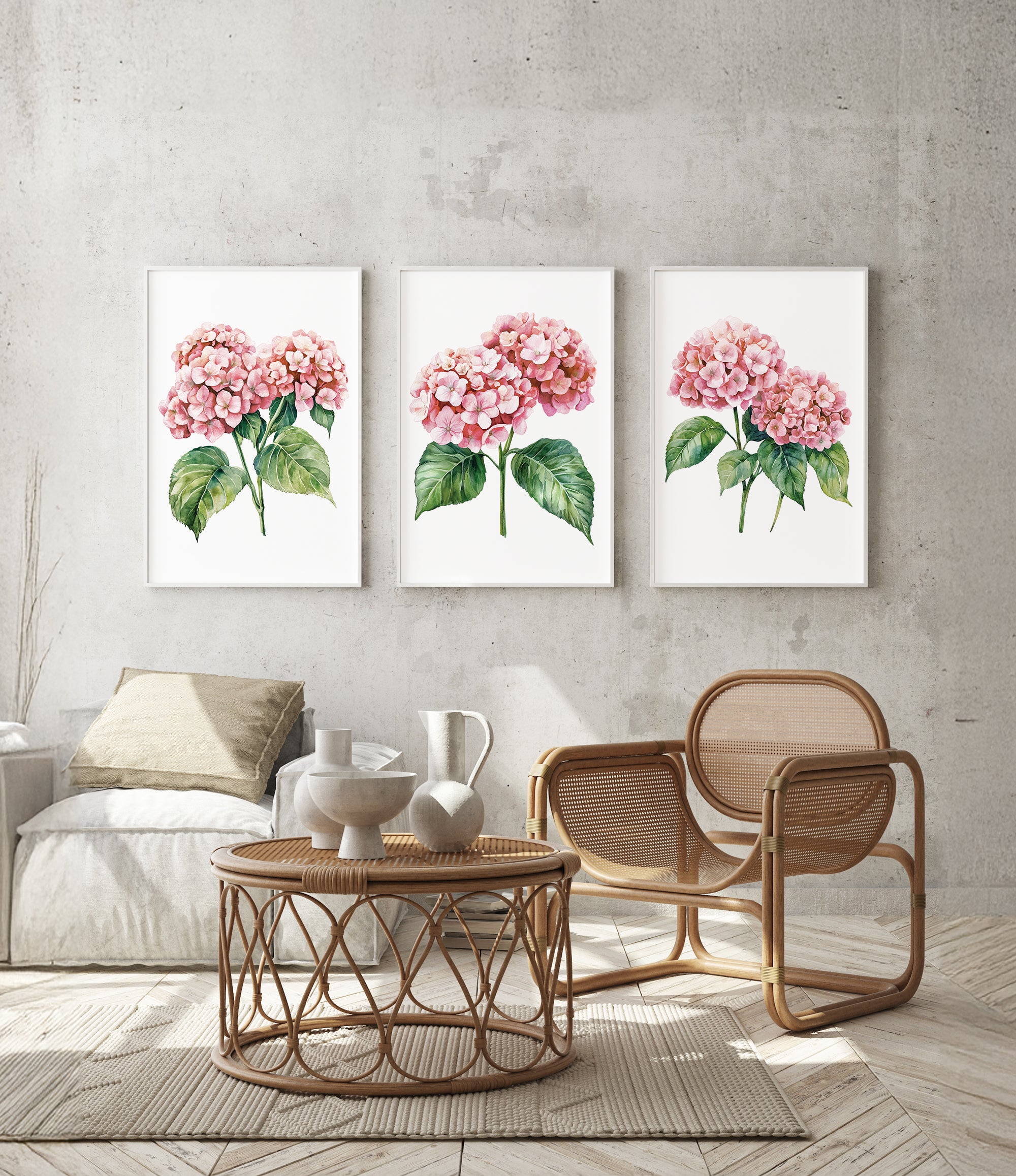 a cozy living room with a wicker coffee table, a wooden chair, and three framed watercolor paintings of pink hydrangeas hanging on the wall above the seating area.