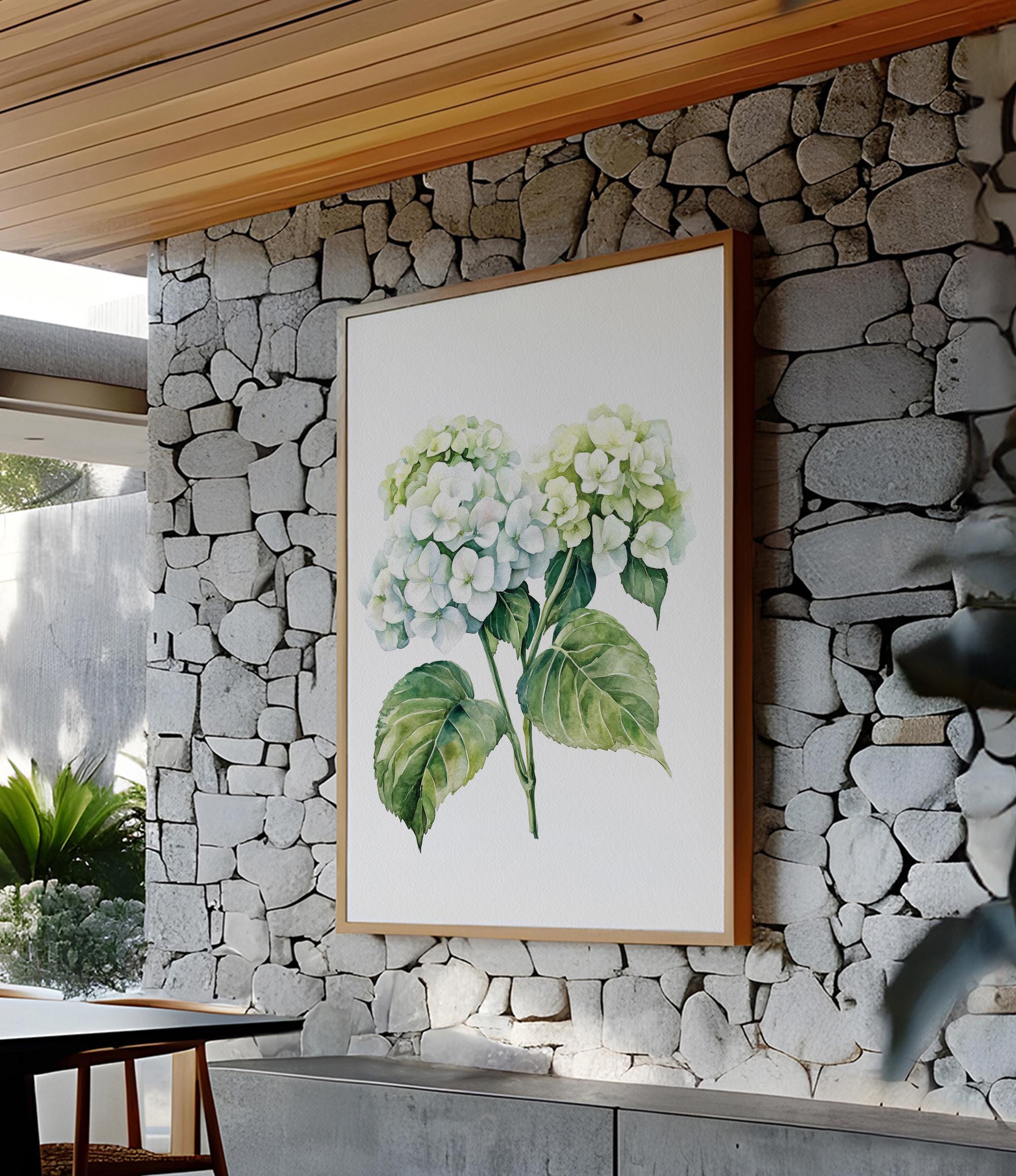 a large framed painting of white hydrangea flowers hanging on a stone wall.