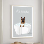 A framed poster with a cartoon image of a dog sitting in a bathtub filled with bubbles, accompanied by the text "WASH YOUR PAWS".