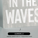 a wooden sign that says in the waves