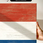 a hand holding a piece of wood with a flag painted on it