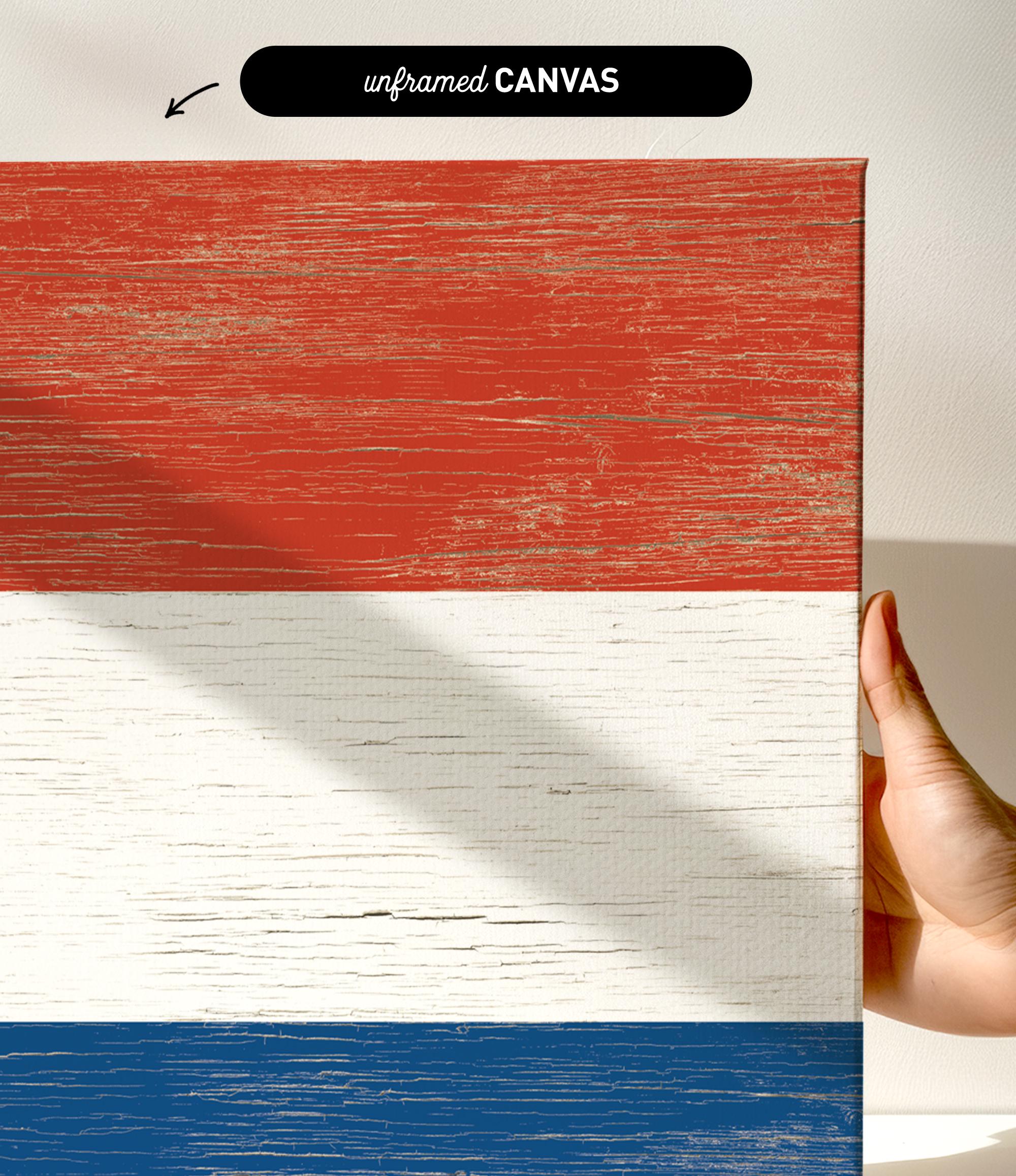 a hand holding a piece of wood with a flag painted on it