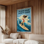 a living room with a large framed poster of a woman surfing on a beach, accompanied by the text "BEACH HAIR DON'T CARE".