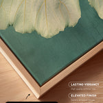 a close-up view of a canvas print with a natural frame, showcasing a vibrant green and beige leaf texture.