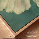 a close-up view of a canvas print with a natural frame, showcasing a vibrant green and beige leaf texture.